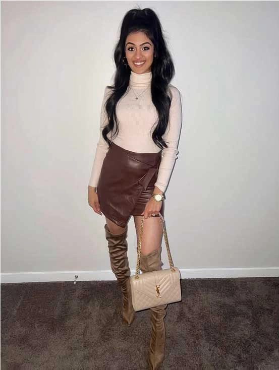 Woman wearing a beige turtleneck, brown leather mini skirt, taupe knee-high boots